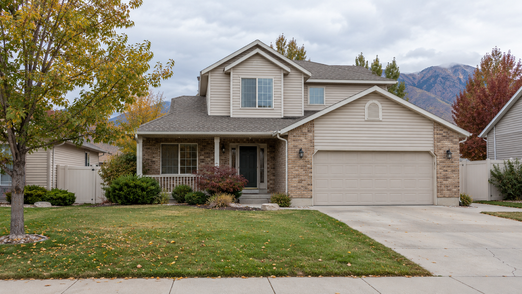 Two-story Utah home with autumn trees and mountains in the background